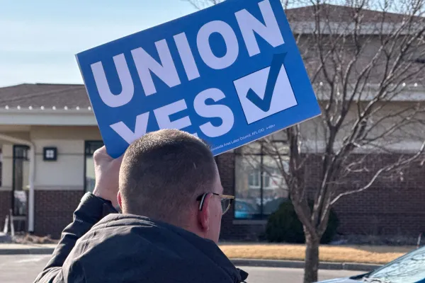 A person holding a sign that says "UNION YES."