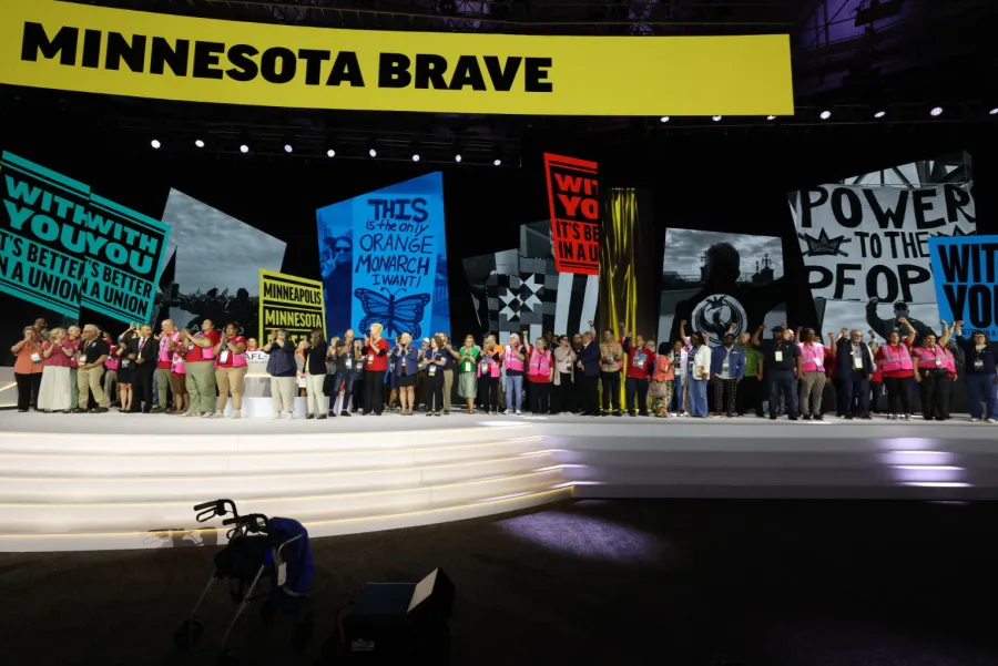 Photo of Minnesota union members on stage at the national AFL-CIO convention with a video wall that reads "Minnesota Brave" overhead.