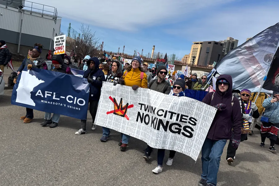 Photo of a group of people holding banners at a protest. One banner is the Minnesota AFL-CIO's logo, the other says "TWIN CITIES NO KINGS"